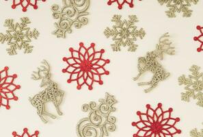 Trendy pattern made with various red and golden Christmas and New Year objects on pastel cream background. Minimal Christmas or New Year concept. Creative flat lay luxury pattern background. photo