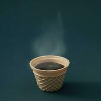 Closeup view of hot steaming coffee in waffle ice cream cone against black background. Minimal coffee aesthetic concept. Creative ice cream coffee idea. photo