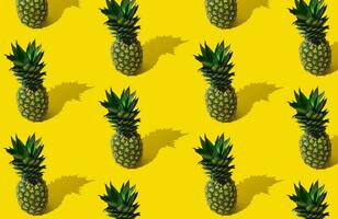 Fresh tropical summer fruit pattern made of pineapple on light yellow background. Trendy minimal ananas pattern layout. Natural exotic summer food concept. Pineapple aesthetic. photo