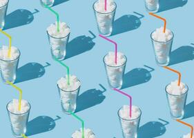 Creative pattern composition made of glasses full of sugar cubes with colorful drinking straws on bright light blue background. Minimal unhealthy diet concept. Be healthy lifestyle idea. photo