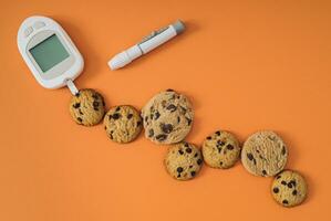 determinando el aproximado concentración de glucosa en chocolate galletas. creativo médico dispositivo y dulce chocolate galletas concepto. mínimo plano laico médico antecedentes idea. foto