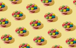 Creative colorful pattern made of various macarons on pastel yellow background. Minimal sweet food concept. Trendy macaron cookies pattern background. photo