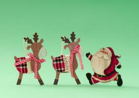 Christmas reindeers and Santa Claus against pastel green background. Minimal Christmas or New Year concept. Creative holiday background idea. Copy space. photo