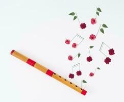 Creative layout made of wooden flute and musical notes made of various flowers on white background. Minimal musical instrument concept. Trendy wooden flute idea. Musical background aesthetic. photo