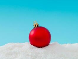 Creative composition made of Christmas bauble decoration on snow. Minimal holiday background. Fancy Christmas or New Year concept. Trendy winter holiday idea. Christmas aesthetic. photo