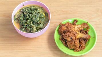 Ayam goreng Kalasan and Gulai daun ubi, Indonesian traditional cuisine made from fried chicken photo