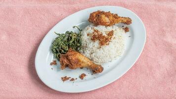 Ayam goreng Kalasan and Gulai daun ubi, Indonesian traditional cuisine made from fried chicken photo