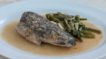 Snakehead fish curry, a gravy dish with snakehead fish, long beans and garlic. photo