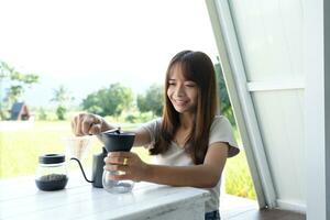 Asian female tourist Grind and brew coffee to drink in the morning. photo