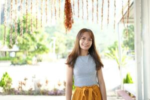 Happy Asian female tourist next to accommodation building during sunset photo