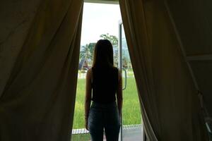 A female tourist opens the curtains and looks at the scenery. photo