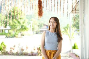 Happy Asian female tourist next to accommodation building during sunset photo