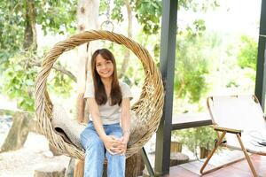 Happy Asian woman sitting at check-in station in coffee shop photo