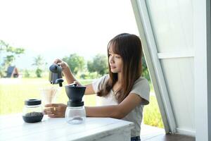 Asian female tourist Grind and brew coffee to drink in the morning. photo