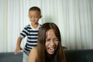 Asian boy massaging mother's shoulders and arms photo