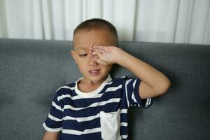 asiático chico tiene dolorido ojos foto