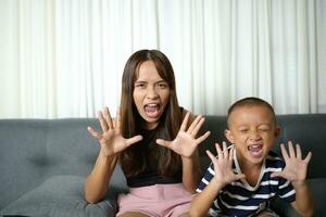 Asian boy and mother doing tiger pose photo