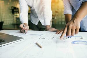 Structural engineering designers are working on the blueprints and analyzing them together. photo