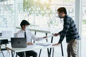 Employees submit documents at their office while wearing masks during the outbreak of the virus. photo