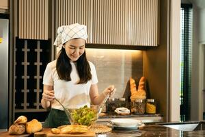 Asian housewife preparing fresh vegetables to make salad at home kitchen counter. photo
