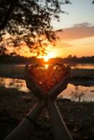 silueta de manos formando corazón forma con puesta de sol fondo foto