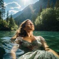 Peaceful image of a woman floating on her back in a tranquil lake photo