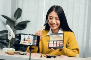 Young Asian beauty blogger is showcasing cosmetic products as well as tutorials on how to apply and record makeup tutorials on social media networks. photo