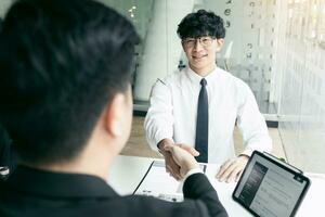 Manager and employee interview concept with handshake after talking about contract signing. photo