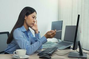 Stress asian woman while coding data programmer on desktop PC while working on computer codes in the office. photo