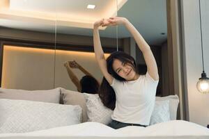 Asian woman stretching as she wakes up in the morning. photo