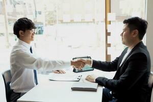 Manager and employee interview concept with handshake after talking about contract signing. photo