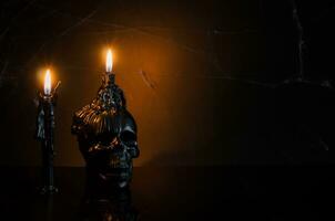 Black skull and candles with flame put on black background with cobweb. Halloween party concept. photo