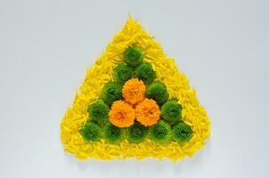 Decorative rangoli made from colorful marigold flowers and petals with green Chrysanthemum for Diwali festival on white background. photo