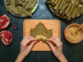 At home, cooking dolma in grape leaves photo