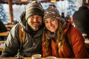 Couples snowshoeing in winter gear pausing for hot drinks and toasted sandwiches photo