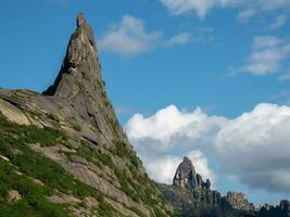 Pointed cliff, a misty mountainside. Ghost rocks. Awesome scenic mountain landscape with big cracked pointed stones closeup in misty morning. Sharp rocks background. Western Sayans photo