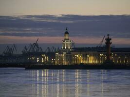 anochecer ciudad centro. primavera noche en S t. petersburgo hielo en el neva río. ver de el rastral columnas y gabinete de curiosidades a atardecer, ciudad vida, tarjeta postal ver de el noche ciudad. foto