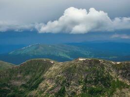 Western Sayans summer landscape view. White clouds over a mountain green valley. Majestic view of the mountain hills. photo