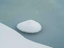 Selective focus. Spring ice, small snowy round island on melting ice. Abstract natural background. photo