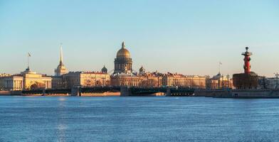 Panorama of spring St. Petersburg with a view of St. Isaac's Cathedral. View from the Neva River. Sunset view of the Palace Bridge, city life, postcard views of the evening city. photo