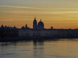 Golden spring sunset in city. Saint Petersburg cityscape over Neva River in Russia. City skyline colorful photo with historical Russian architecture. Postcard view of the city.