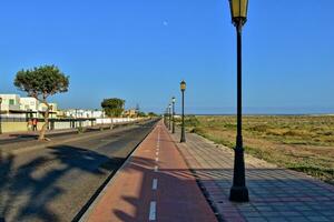 wide asphalt road on the Spanish Canary Island Fuerteventura with palm trees photo