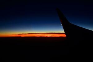 misterioso puesta de sol con nubes desde el avión ventana con foto