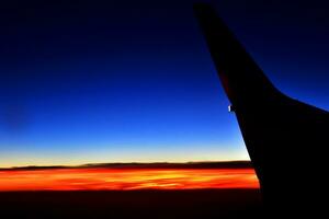 misterioso puesta de sol con nubes desde el avión ventana con foto