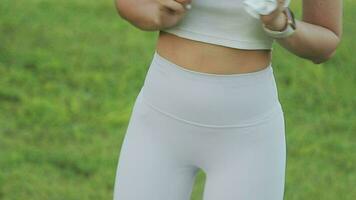 joven mujer extensión antes de corriendo mientras mirando para hermosa paisaje en borde del camino. Deportes y recreación video