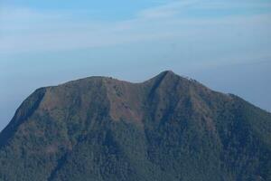 view of the peaks of several mountains at sunrise in the morning photo