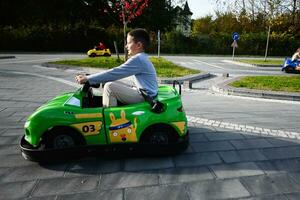 Go-karting in the park. Boy on green car. photo