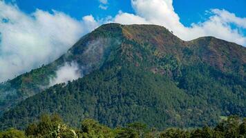 view of mountains with white clouds in the sky photo