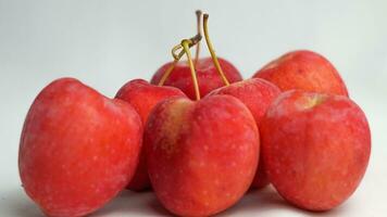 This fruit is called a strawberry apple, it tastes like an apple with a shape like a strawberry photo