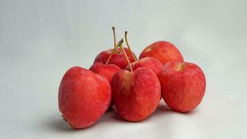 This fruit is called a strawberry apple, it tastes like an apple with a shape like a strawberry photo